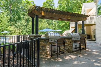 Pergola covering community gas grills next to the pool deck.